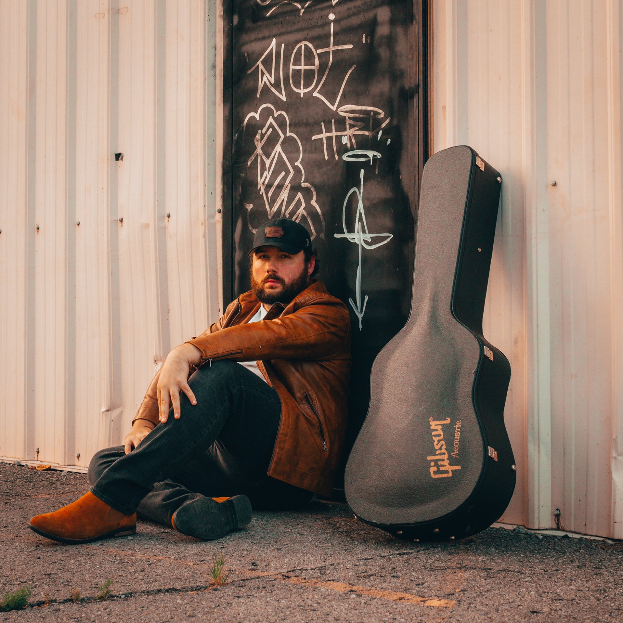 Jesse Allen walking with Gibson guitar case in the rain